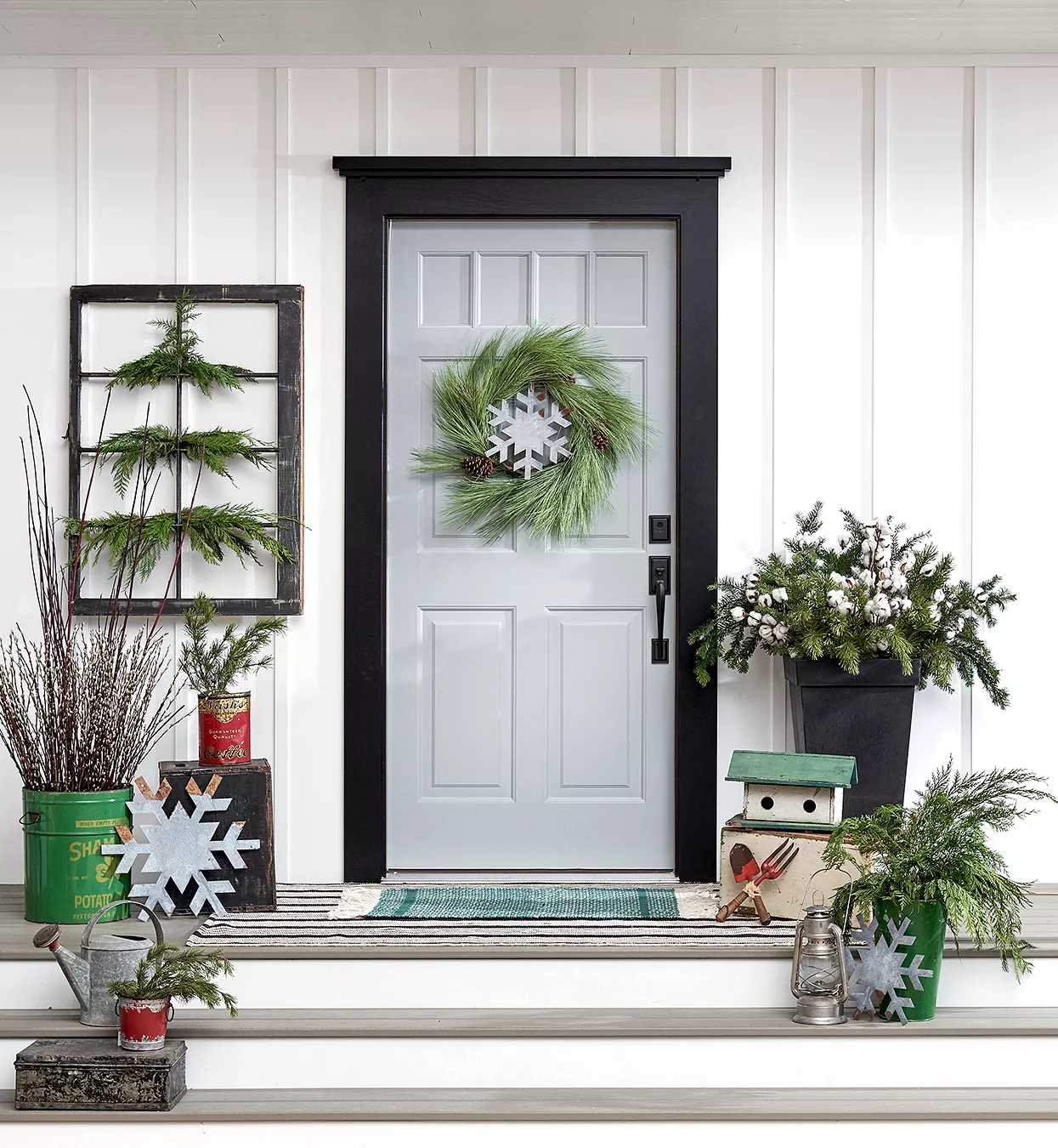 outdoors-inspired decorated holiday porch with rake and window frame