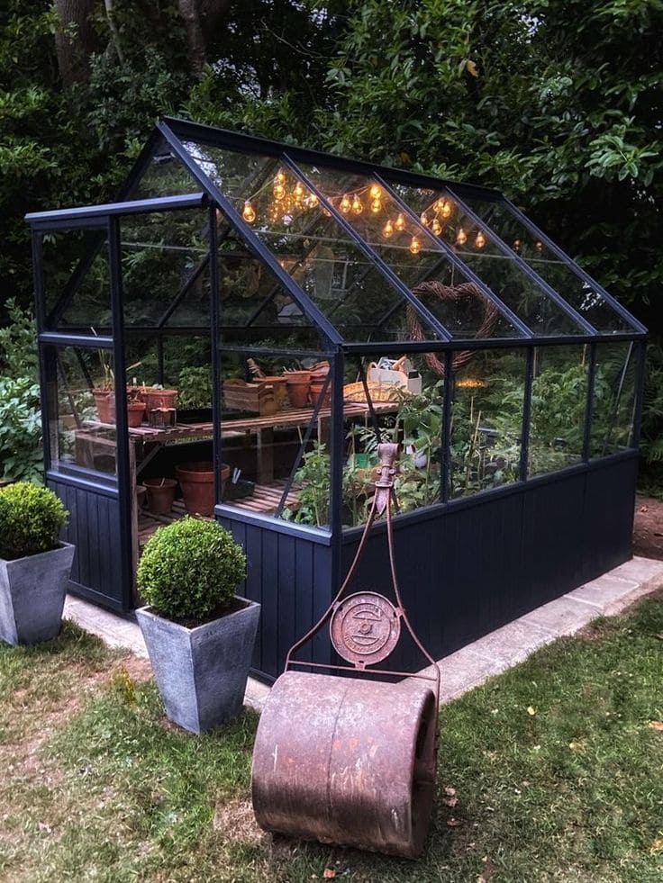 Black-Frame Glass Greenhouse with String Lights