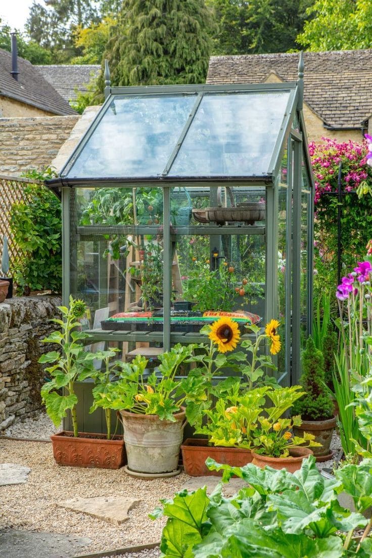 Elegant Glass Greenhouse Surrounded by Vibrant Flowers