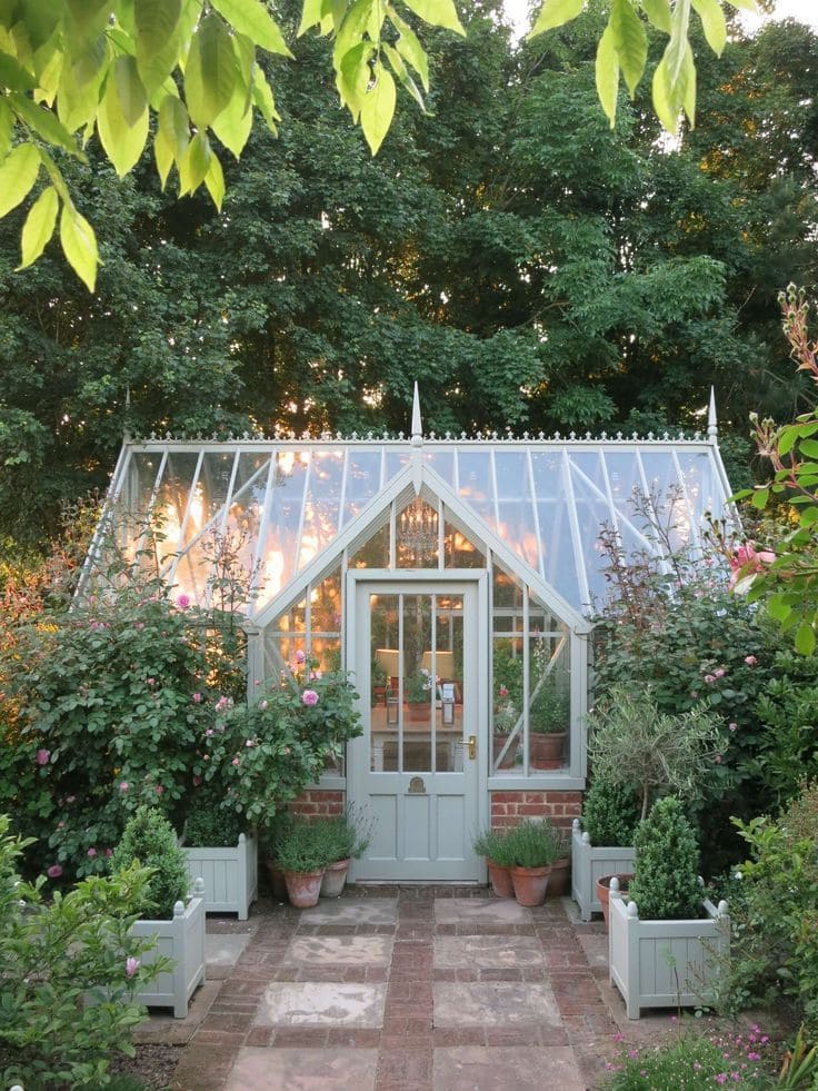 Glass Greenhouse Surrounded by Lush Garden Blooms