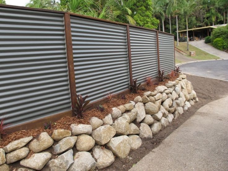 Modern Corrugated Fence with Stone Retaining Wall